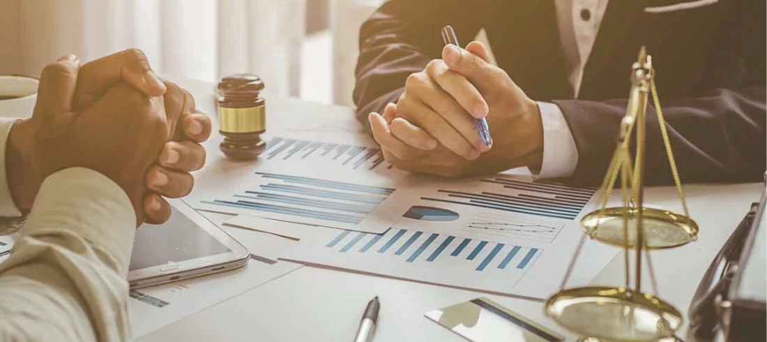 Deux personnes autour d’une table évaluant le préjudice économique subi par une personne morale par ricochet, suite au dommage corporel d’un dirigeant