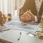 Deux personnes autour d’une table évaluant le préjudice économique subi par une personne morale par ricochet, suite au dommage corporel d’un dirigeant