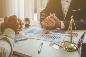 Deux personnes autour d’une table évaluant le préjudice économique subi par une personne morale par ricochet, suite au dommage corporel d’un dirigeant