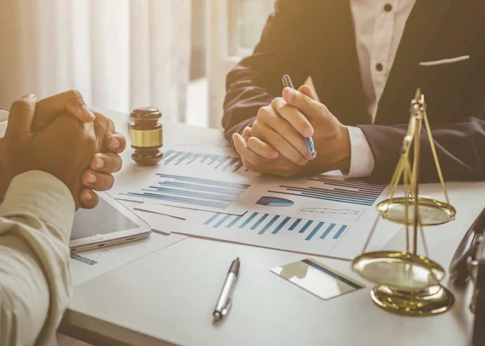 Deux personnes autour d’une table évaluant le préjudice économique subi par une personne morale par ricochet, suite au dommage corporel d’un dirigeant