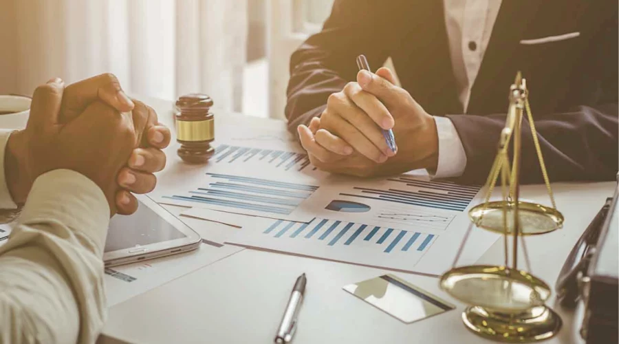 Deux personnes autour d’une table évaluant le préjudice économique subi par une personne morale par ricochet, suite au dommage corporel d’un dirigeant